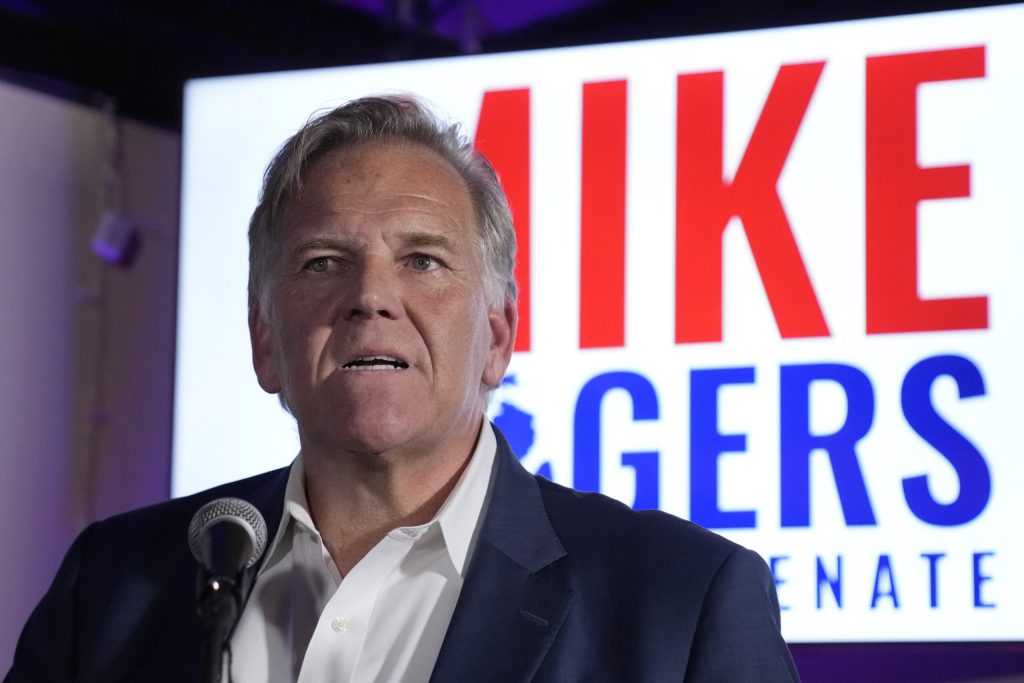 Michigan U.S. Senate candidate Mike Rogers, a middle-aged man wearing a black suit and white shirt.