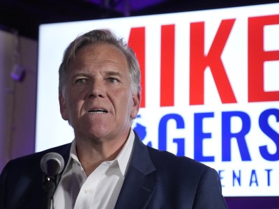 Michigan U.S. Senate candidate Mike Rogers, a middle-aged man wearing a black suit and white shirt.