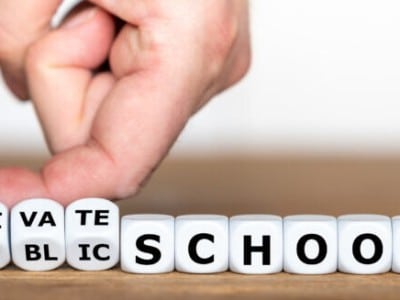 Private or public school? Hand turns dice and changes the expression "public school" to "private school".