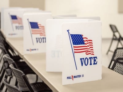 A polling location in Jefferson City, Missouri, with white folders that say "vote" set up on tables.