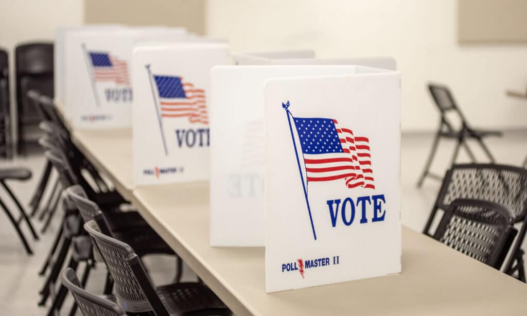 A polling location in Jefferson City, Missouri, with white folders that say "vote" set up on tables.