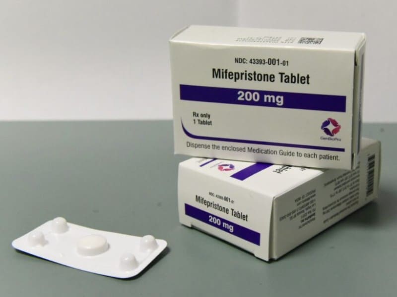 Two boxes of GenBioPro Mifepristone Tablets (200 mg) next to a blister pack containing a single white pill.