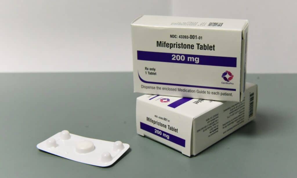 Two boxes of GenBioPro Mifepristone Tablets (200 mg) next to a blister pack containing a single white pill.