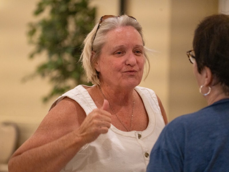 Cindy Burbank smiles and gives a thumbs-up while speaking to a person seen from behind
