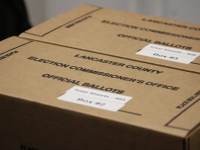 Two closed cardboard boxes labeled "Lancaster County Election Commissioner's Office - Official Ballots."