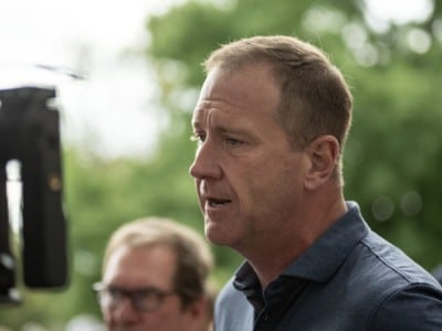 U.S. Sen. Eric Schmitt speaks outdoors in profile near a video camera