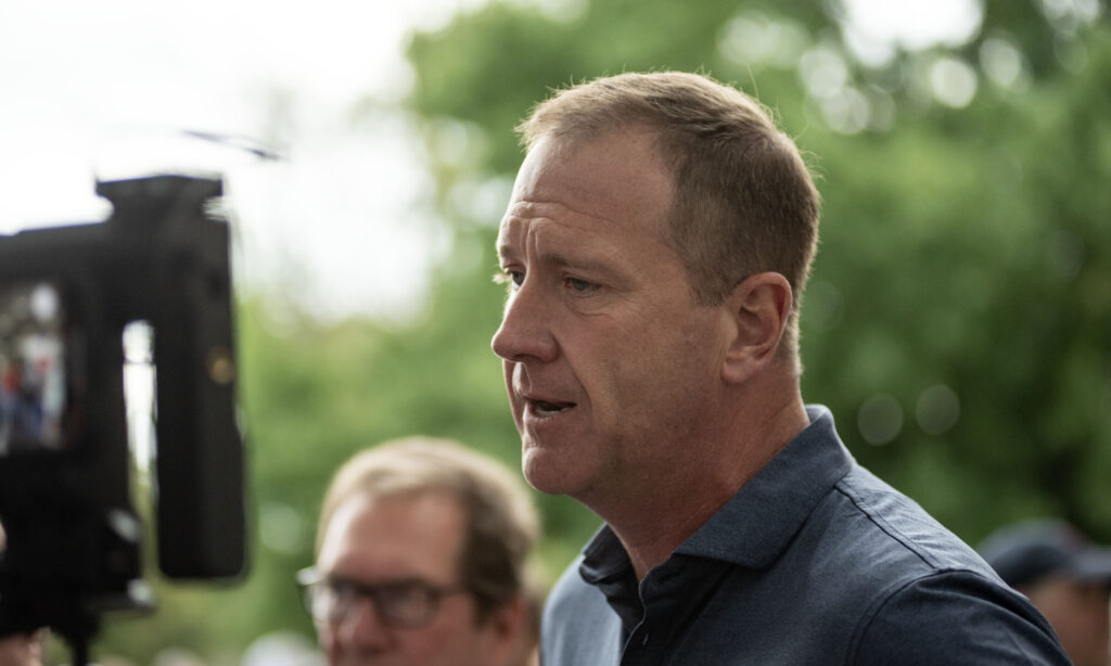 U.S. Sen. Eric Schmitt speaks outdoors in profile near a video camera
