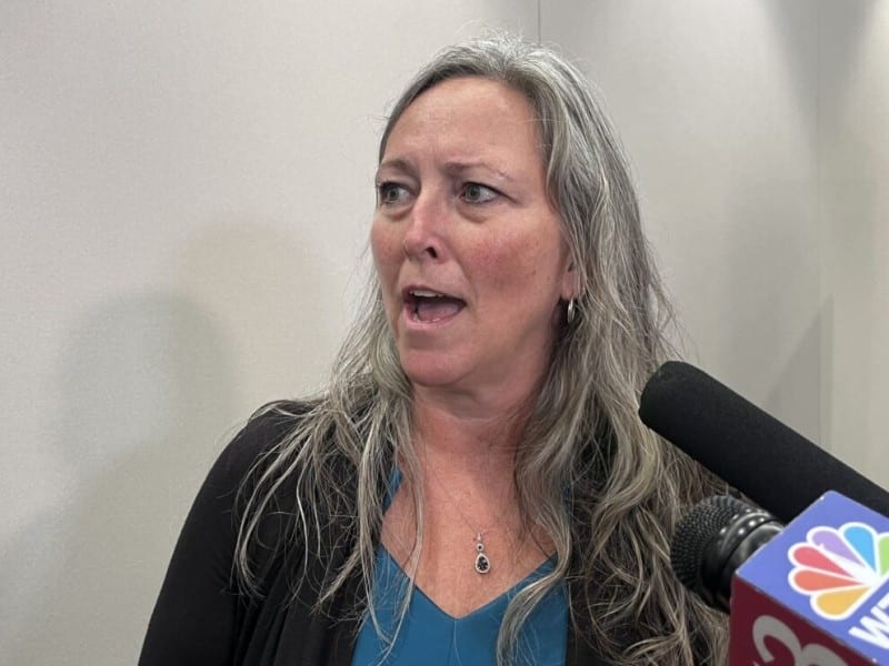 Paula Copenhaver speaks into microphones during an interview.