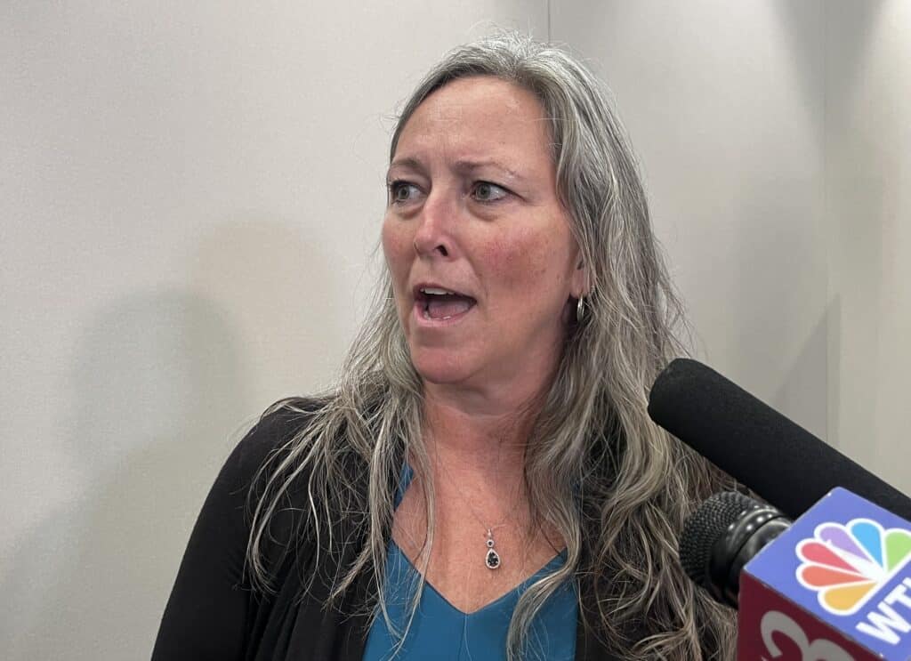 Paula Copenhaver speaks into microphones during an interview.