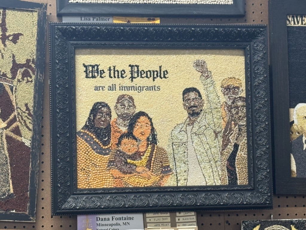 Seed art depicting a diverse group of people under text reading "We the People are all immigrants."