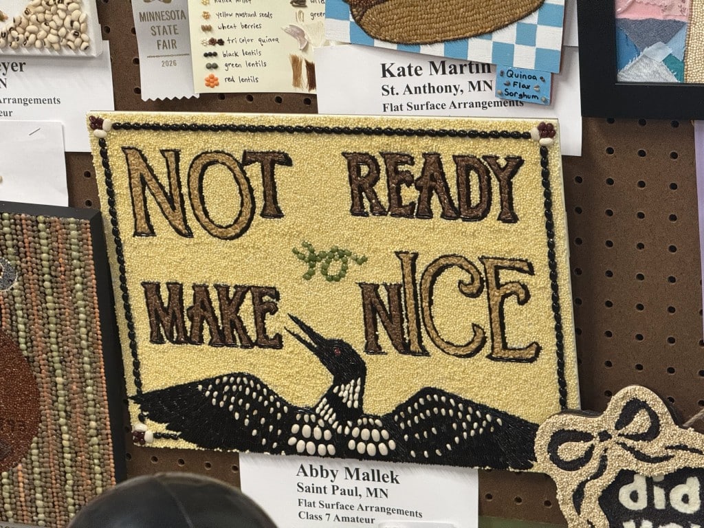 Seed art featuring a loon with its wings spread beneath the phrase "NOT READY TO MAKE NICE."