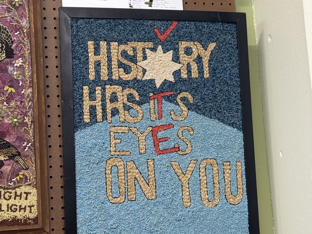 Seed art spelling "HISTORY HAS ITS EYES ON YOU" with red letters and a checkmark highlighting "VOTE."