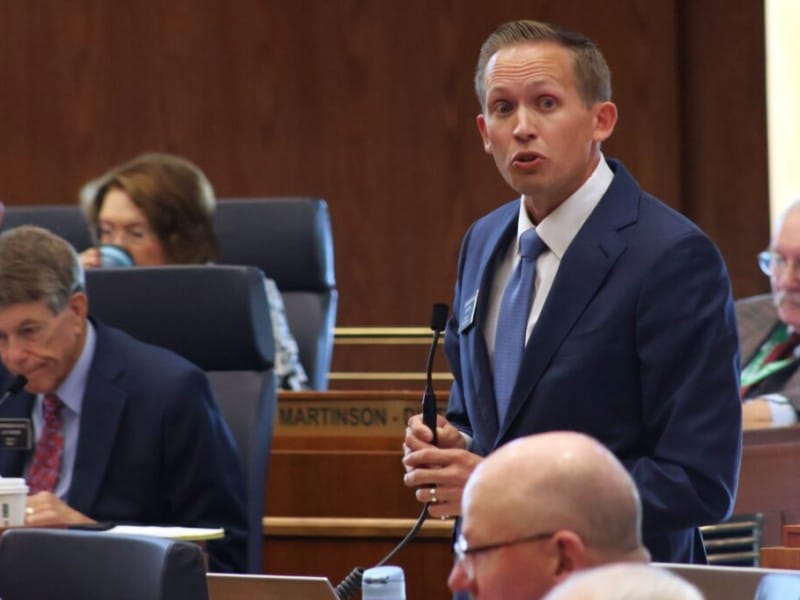 North Dakota House Minority Leader Zac Ista stands and speaks into a microphone on the House floor.