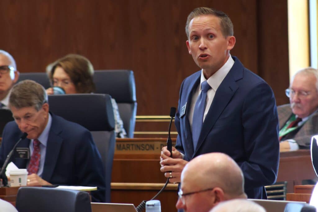 North Dakota House Minority Leader Zac Ista stands and speaks into a microphone on the House floor.