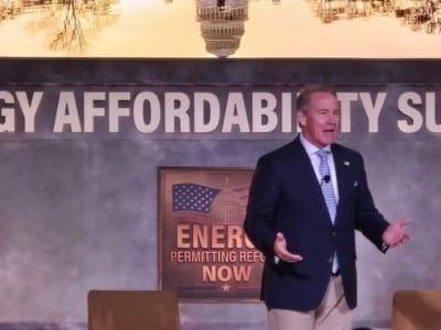 Jon Husted speaks on stage in front of a banner reading "Energy Affordability Summit."