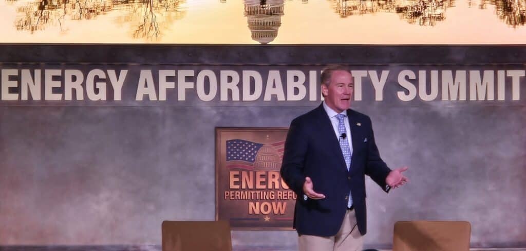 Jon Husted speaks on stage in front of a banner reading "Energy Affordability Summit."