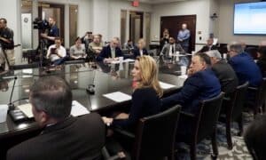 Members of the Oklahoma House Rules Committee sit around a large conference table during a meeting.