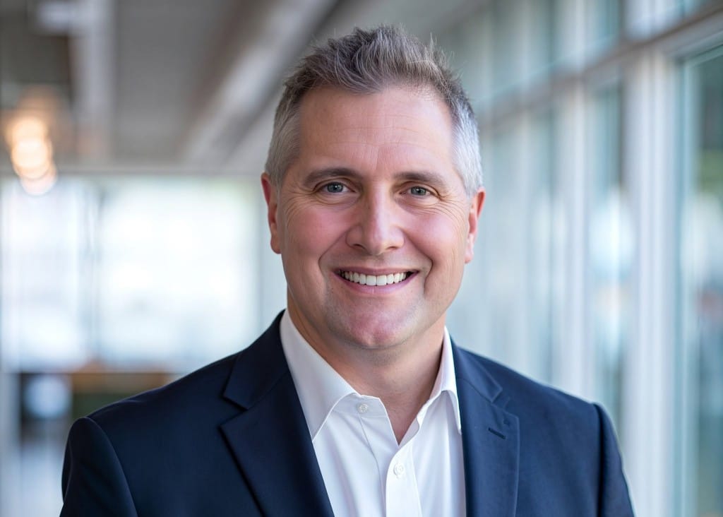Headshot of Wisconsin state Rep. Shannon Zimmerman smiling in a dark blazer and open-collared white shirt.