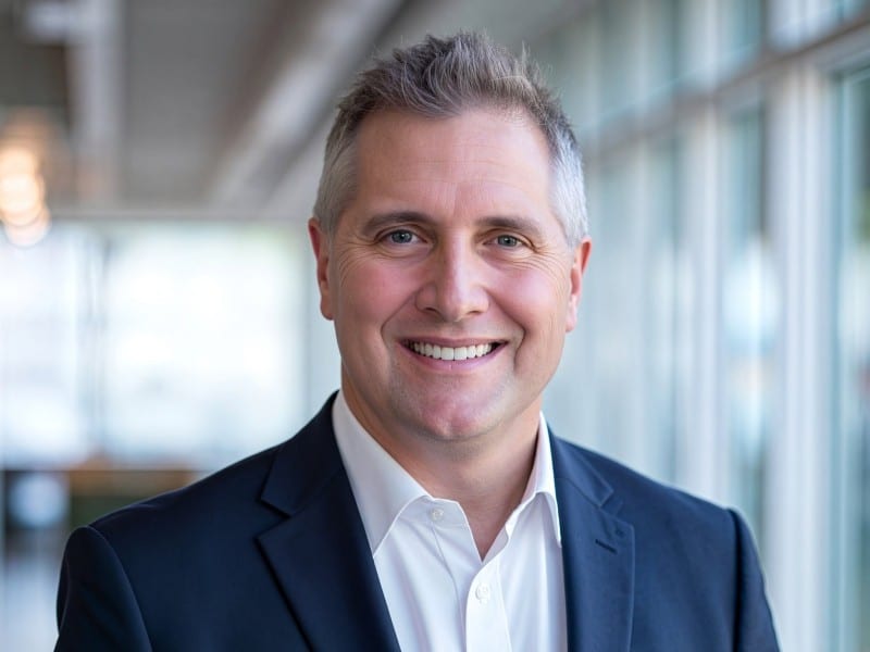 Headshot of Wisconsin state Rep. Shannon Zimmerman smiling in a dark blazer and open-collared white shirt.