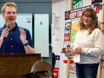 Grant Hauschild speaks at a wooden podium, and Andrea Zupancich stands next to campaign signs holding rolled papers.
